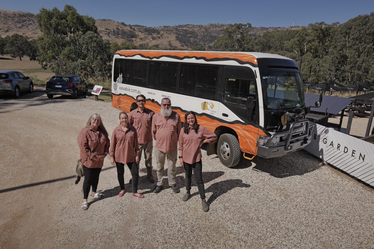 wawa biik team standing in front of bus